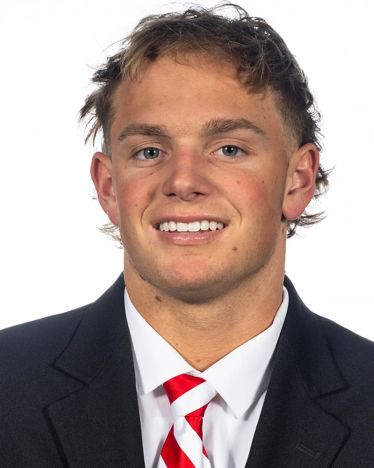Anthony Colandrea in a dark suit and red-striped tie, photographed against a white background.