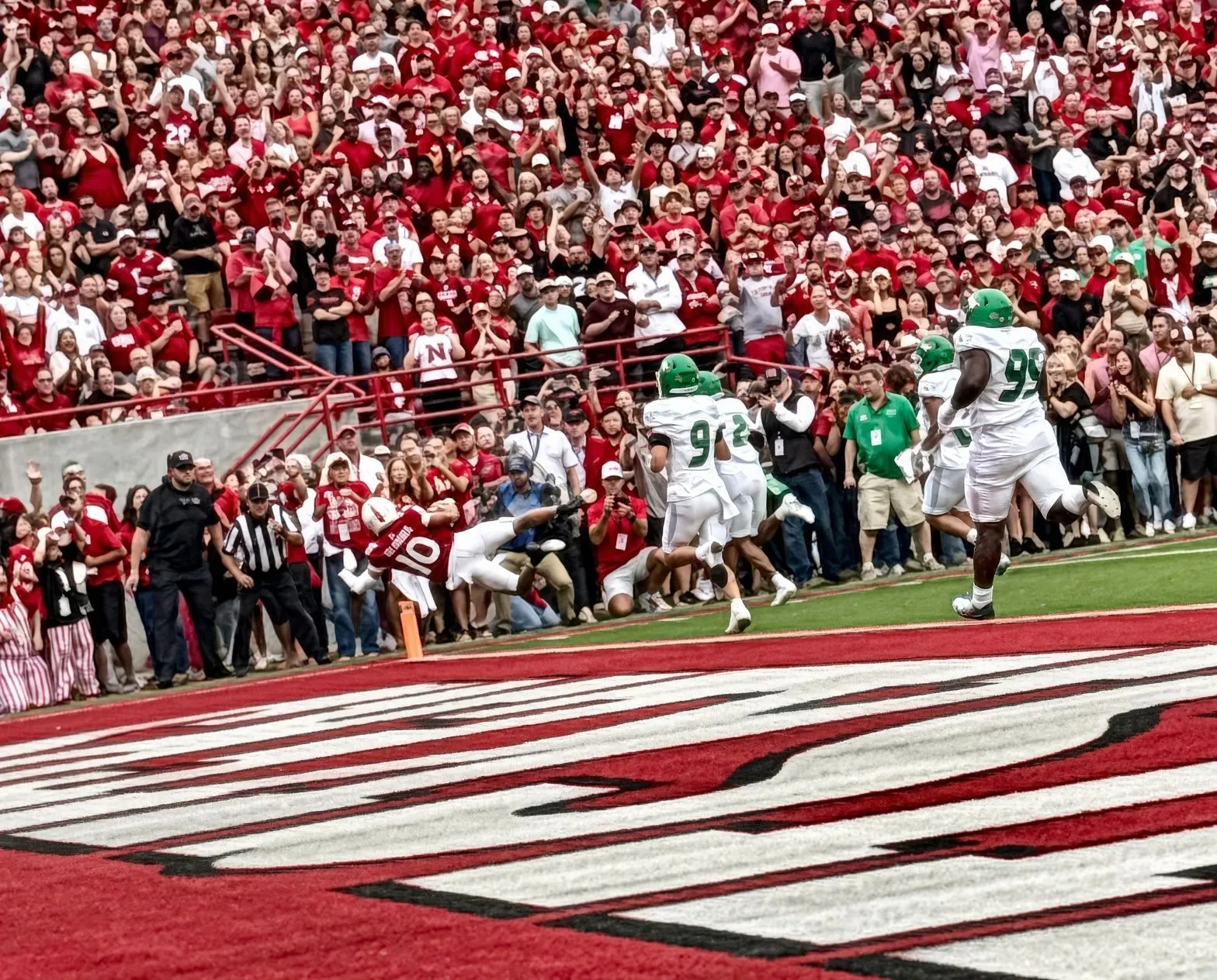 Anthony Colandrea dives past the pylon for Nebraska's first touchdown against North Dakota as three Fighting Hawks defenders give chase and the Memorial Stadium crowd comes to its feet.