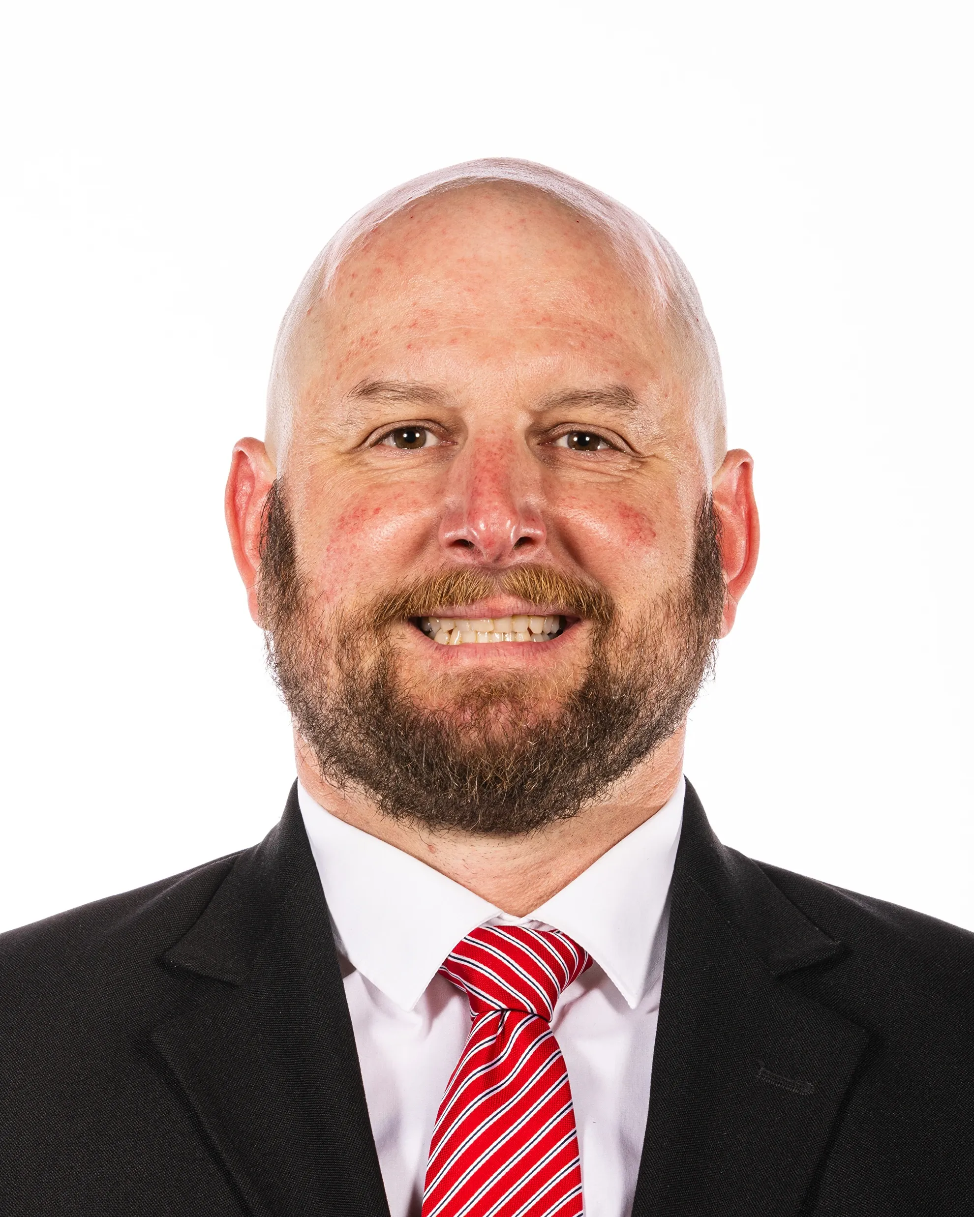 Dave Tollefson in a dark suit and red-striped tie, photographed against a white background.